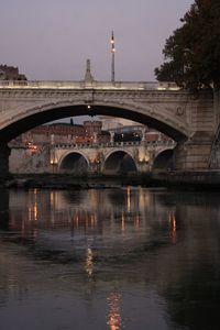 Arch bridge over river against sky