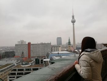 Rear view of woman looking at modern buildings in city