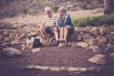 Senior couple with dogs on rocks