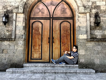 Man sitting by door of church