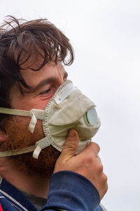 Close-up portrait of a boy holding camera over white background
