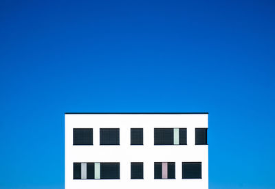 Low angle view of building against clear blue sky