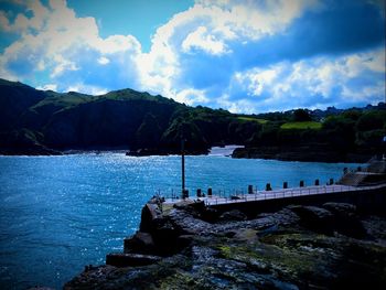 Scenic view of sea and mountains against sky