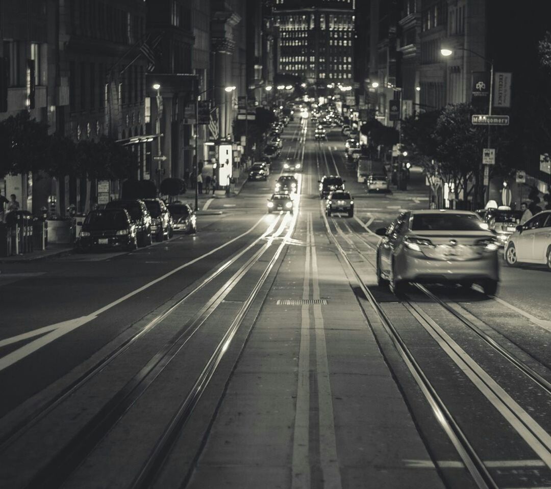 city, transportation, building exterior, architecture, built structure, car, mode of transport, land vehicle, street, city life, illuminated, city street, road, night, traffic, the way forward, road marking, street light, incidental people, high angle view