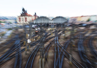 Blurred motion of railroad tracks in city against sky