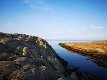 Rock formations by sea against sky