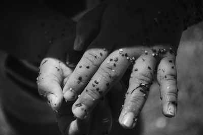 Cropped hands on person covered with small stones