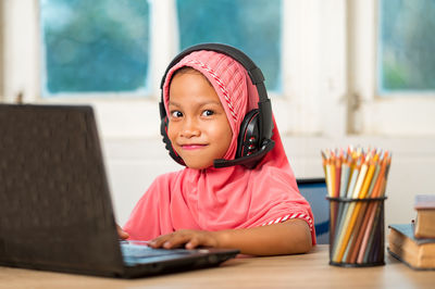 Portrait of smiling girl sitting at table