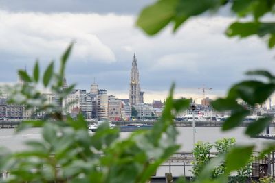 Buildings in city against cloudy sky