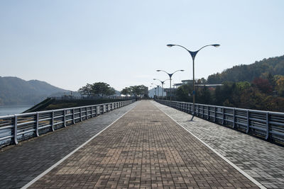 Street by river against clear sky