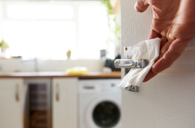 Midsection of man using smart phone at home