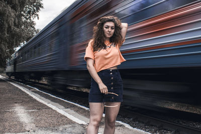 Portrait of woman standing on railroad track