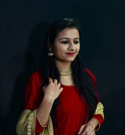 Portrait of a beautiful young woman against black background