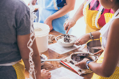 Midsection of people preparing food on table