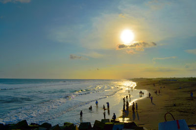 Group of people on beach at sunset