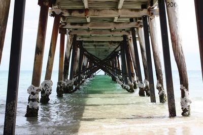 Wooden pier over sea against sky