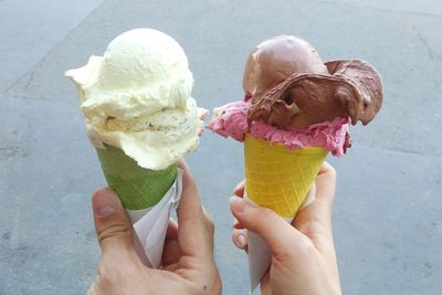 Cropped hands of friends holding ice cream cones