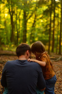 Rear view of couple walking in forest