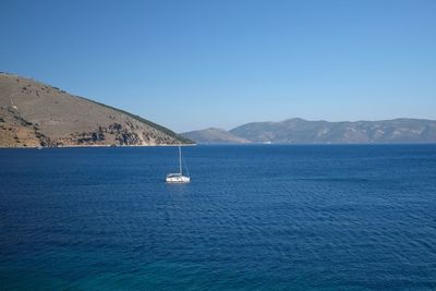 Sailboat in sea against clear blue sky