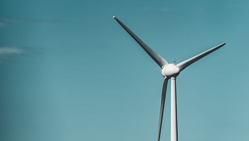 Low angle view of windmill against clear blue sky