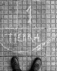 Low section of man standing on tiled floor