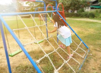 Rear view of girl playing in playground