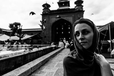 Portrait of woman standing by railing