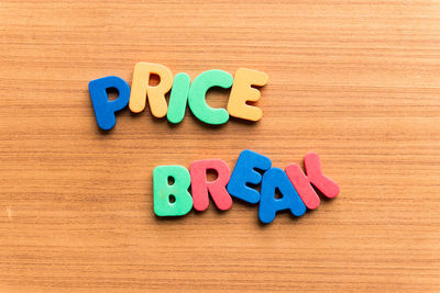 High angle view of colorful price break text on wooden table