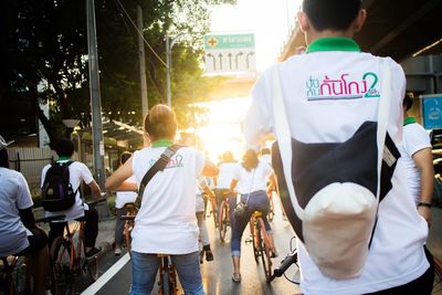 Rear view of people walking on street in city