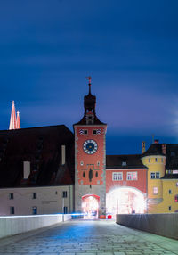 View of buildings in city against blue sky at night