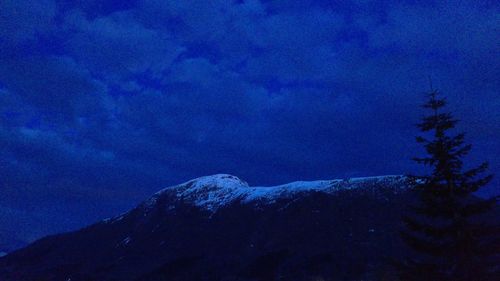 Low angle view of snow mountains against sky at night