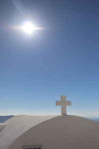 Cross against blue sky on sunny day