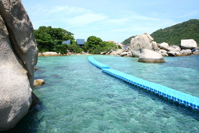 Swimming pool by sea against sky