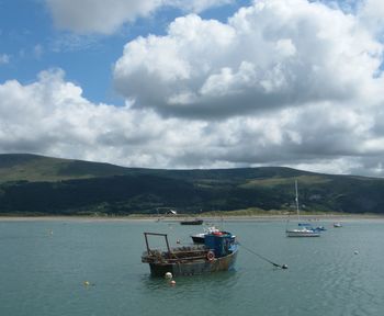 Boats sailing on sea against sky