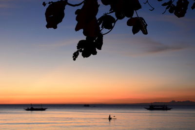 Silhouette boats in sea against sky during sunset