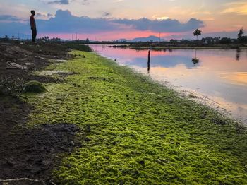 Scenic view of river against sky at sunset