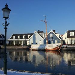 Boats in harbor against clear sky