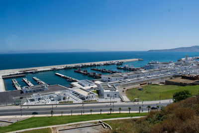 High angle view of road by sea against clear blue sky