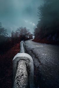 Road amidst trees against sky in forest