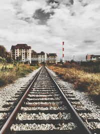 Railroad track against cloudy sky