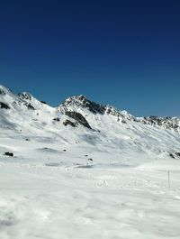 Scenic view of snowcapped mountains against clear blue sky