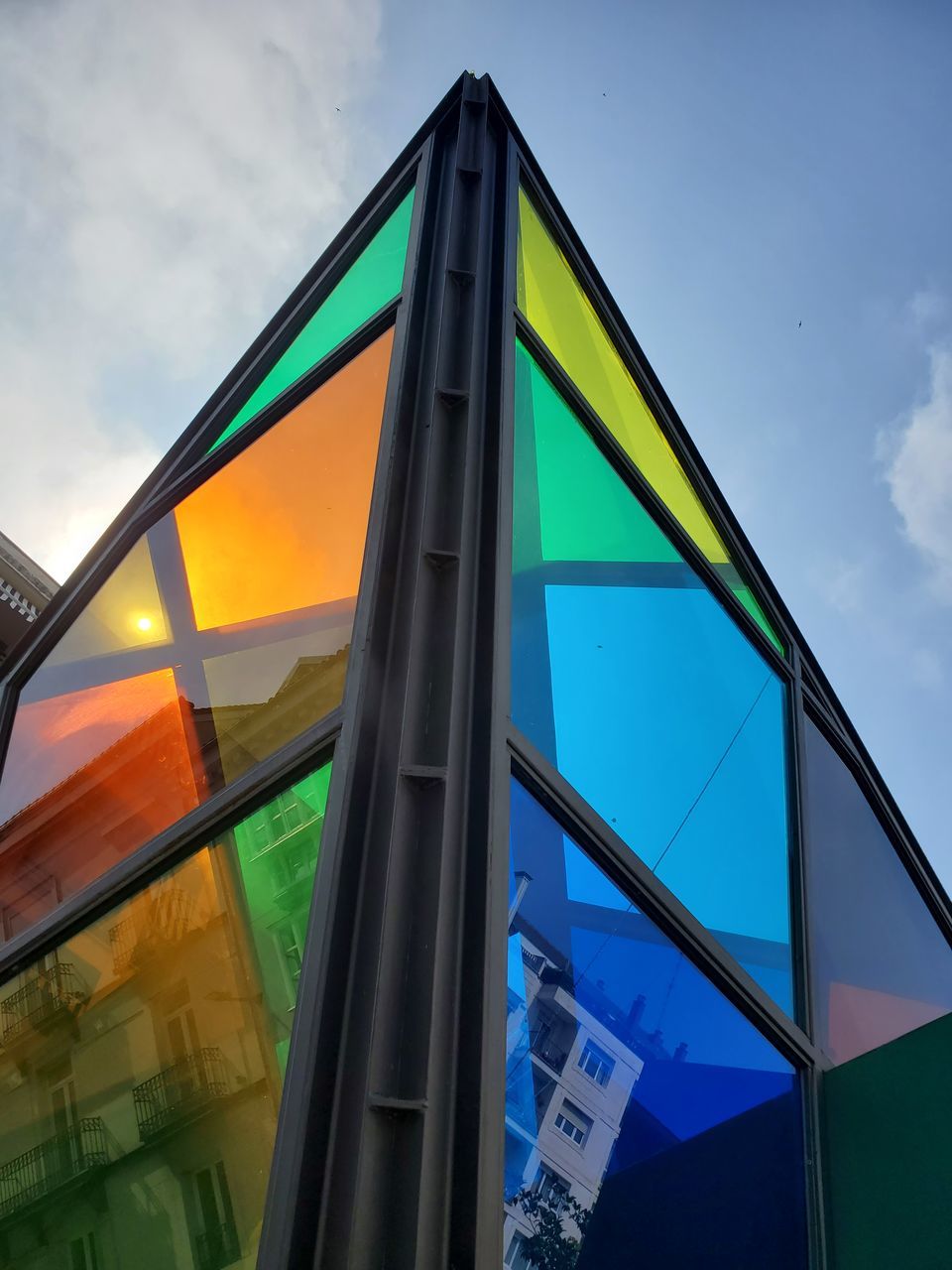 LOW ANGLE VIEW OF GLASS BUILDING WITH REFLECTION