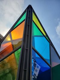 Low angle view of glass building against sky