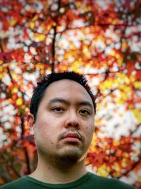 Portrait of young man with autumn leaves