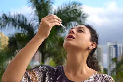 Woman having drop while standing outdoors