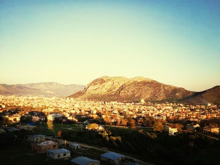 mountain, building exterior, built structure, architecture, clear sky, high angle view, cityscape, copy space, residential district, mountain range, crowded, town, townscape, house, landscape, residential structure, city, residential building, community, scenics