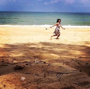 Full length of woman on beach against sky