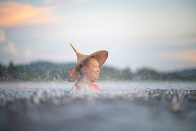 Close-up portrait of woman on land against sky