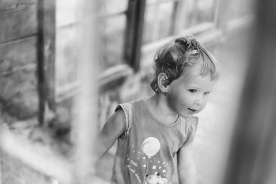 Portrait of baby girl playing in wooden house