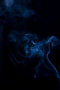 Close-up of blue smoke against black background